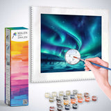 Painting by numbers kit featuring a serene Polarlichter Wunderland scene with paints, brush, and color-coded canvas.