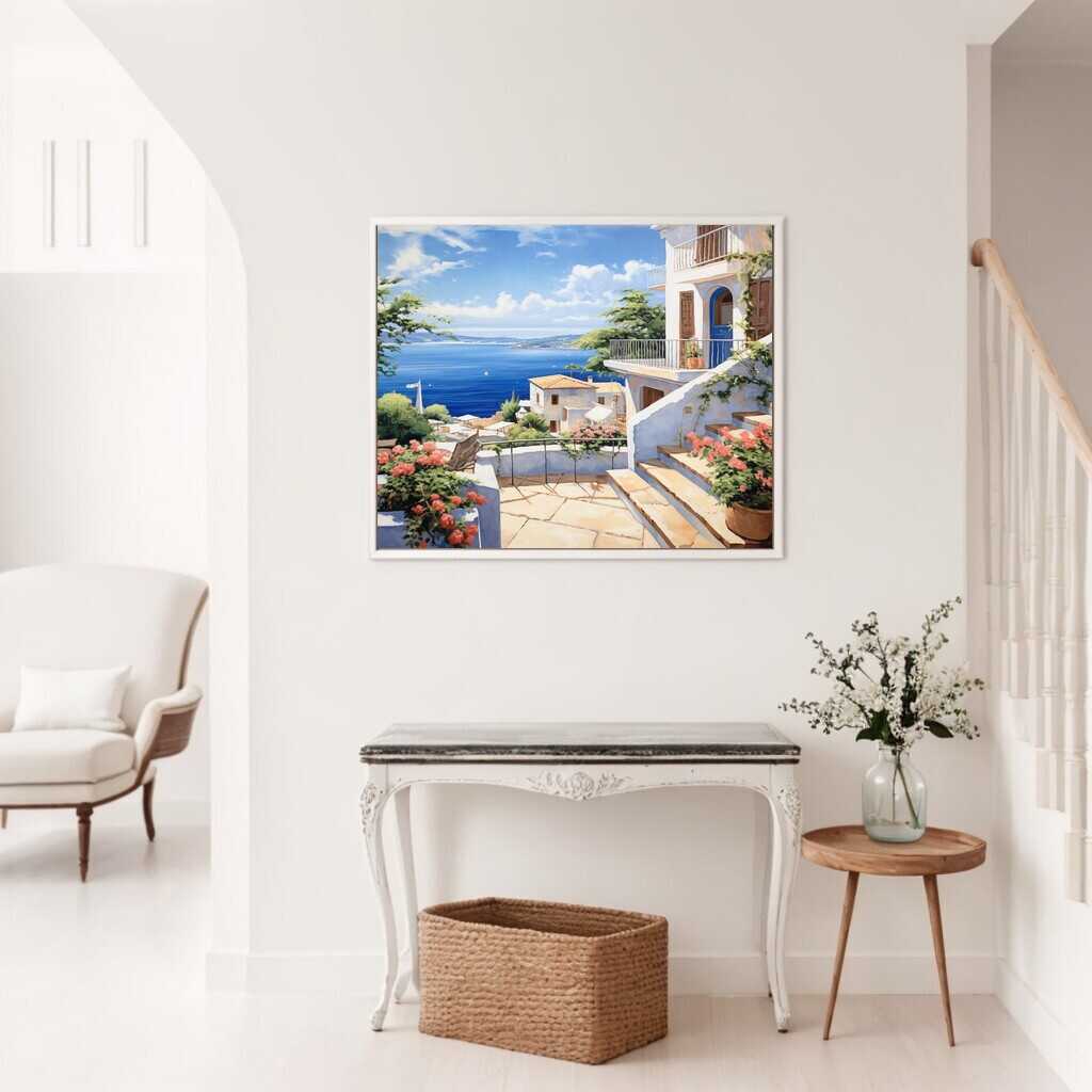 Das Bild "Mittelmeertraum" auf einer weißen Wand mit einem Stuhl, Tisch und Pflanzen im Vordergrund in einem hellen Raum