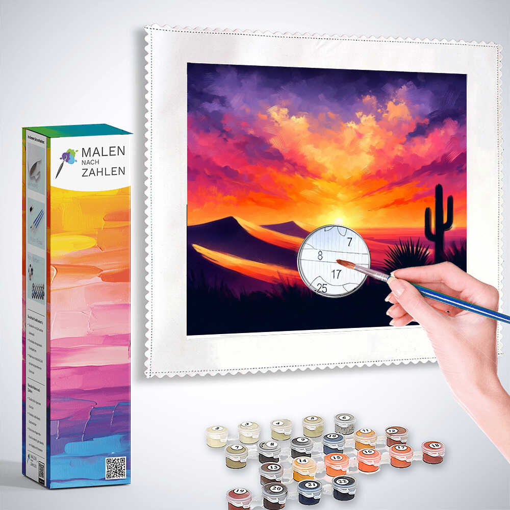 Paint by numbers kit showing a hand painting a vibrant desert sky with a sunset, cacti, and rolling hills, labeled "Malen nach Zahlen - Wüstenhimmel Flamme."