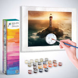 Painting by numbers kit showing a lighthouse at dawn with paints and brush set on rocky cliffs.