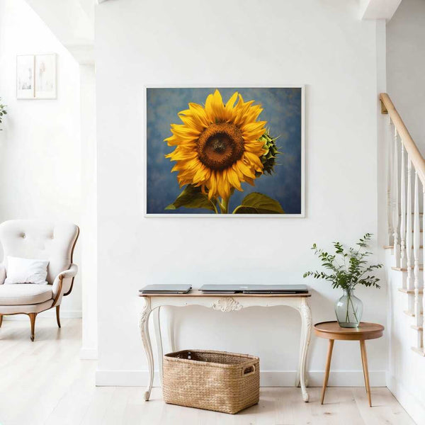 Painting titled 'Sonnentanz' of a sunflower with vibrant yellow petals on a blue background displayed in a bright, airy living room.