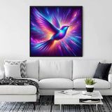 Diamond painting of vibrant Kolibri with purples, pinks, and blues above modern white sofa in living room.