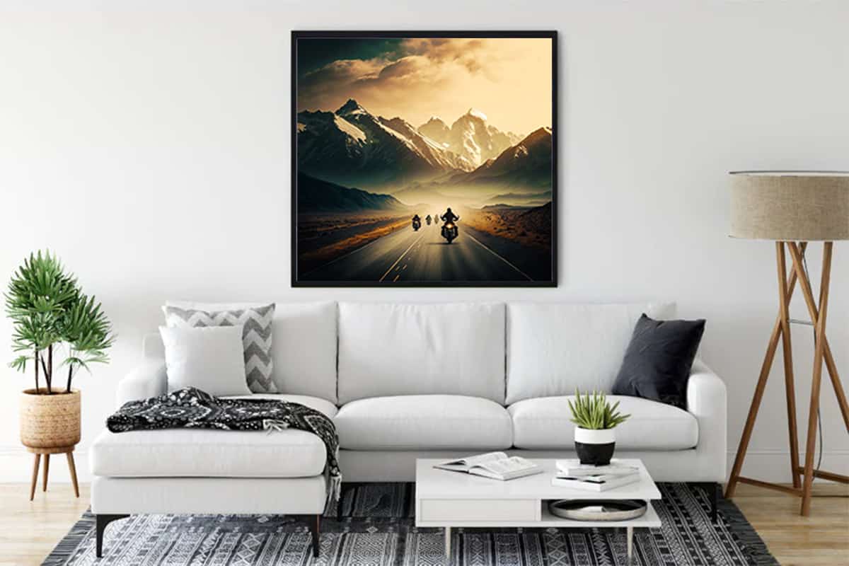 Wall art depicting motorcyclists riding towards snowy mountains, enhancing a modern living room with a stylish, relaxing ambiance.