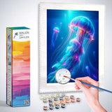 Diamond painting of a glowing jellyfish in deep blue water with vibrant purple and pink hues, surrounded by a painting kit and a hand holding a brush.