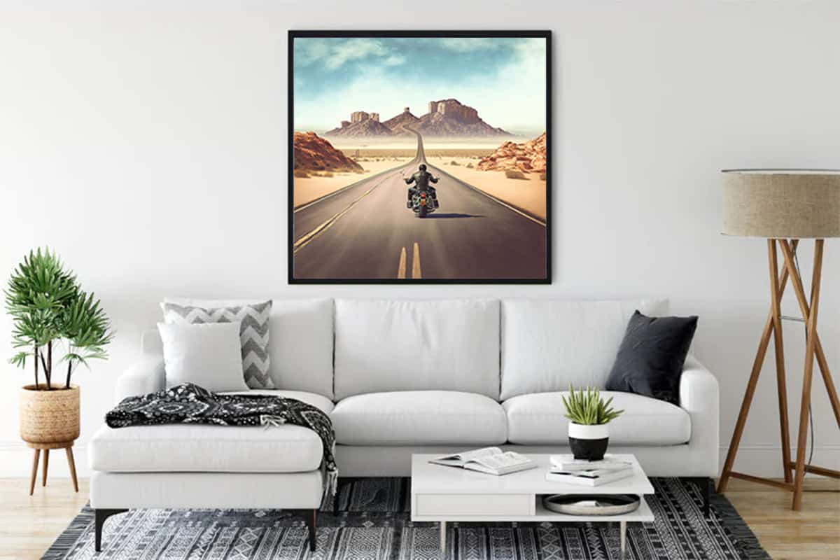 Living room with a framed painting of a motorcyclist on a highway, capturing the essence of freedom and adventure.