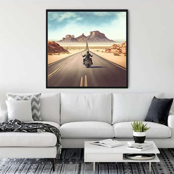 Living room with a framed painting of a motorcyclist on a highway, capturing the essence of freedom and adventure.
