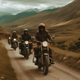 Group of motorcyclists enjoying a scenic ride on mountain road surrounded by green hills and cloudy sky.