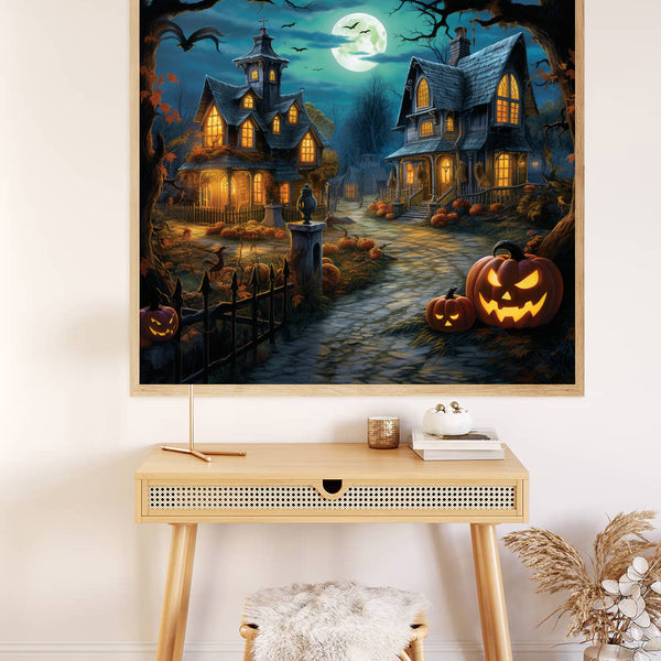 Halloween Nights paint by numbers scene with moonlit haunted houses and glowing pumpkins displayed on wall above a desk.