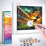 Painting by numbers kit showing a soccer player scoring a goal at sunset with vibrant colors and paint pots included