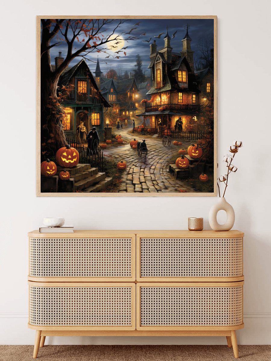 Halloween village scene with carved pumpkins, moonlit sky, and spooky houses on cobblestone street displayed above wooden cabinet.