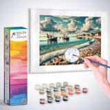 Malen nach Zahlen Set - Küstenflüstern, zeigt friedliches Fischerdorf mit Booten & pastellfarbenem Himmel, Box & Farben enthalten.