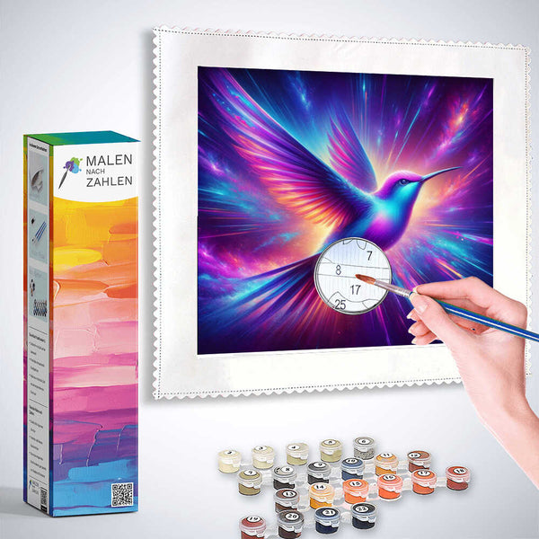 Guided diamond painting kit featuring a vibrant hummingbird in colorful purples and blues with a hand holding a brush ready to paint.