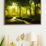 Painting of a serene river in a green forest, framed and hung on a wall above a wooden shelf with plants and a lamp
